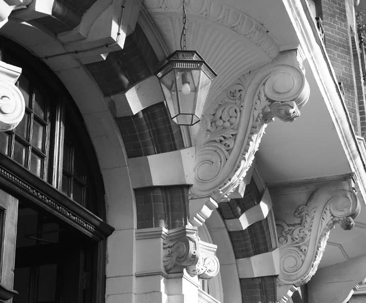 Black and white image of an arched building entrance.